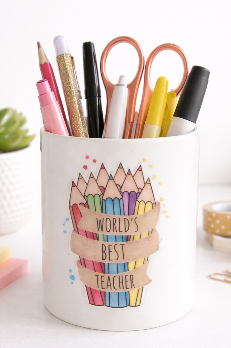 Pencil holder with colourful stationery items and 'World's Best Teacher' text on a white background