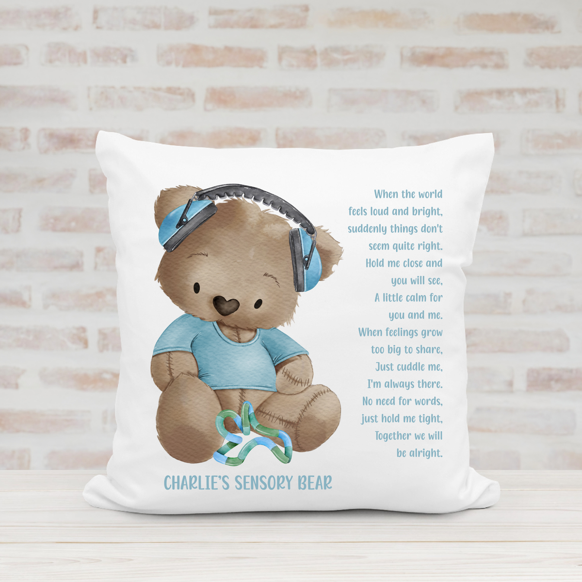 Personalised sensory bear cushion with blue teddy bear design, ear defenders, colourful sensory toy and comforting children's poem.