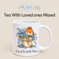 White ceramic memorial mug featuring a watercolour robin perched on a flowerpot of blue forget-me-nots, with the wording Cup of Tea With Mum. Designed and printed by South Shore Gifts.